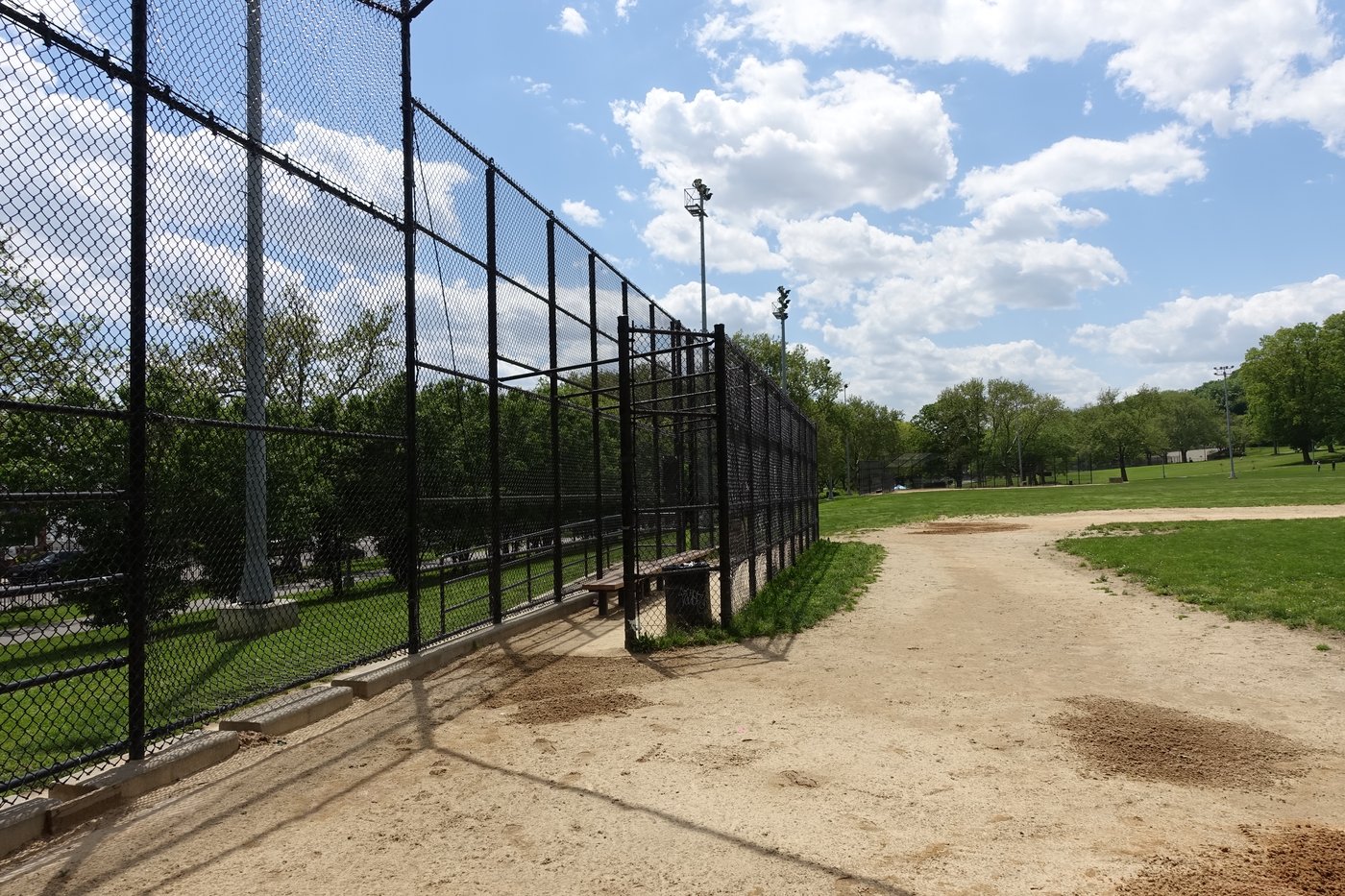 Things baseball parents say — dugout and chain-link fence along a youth baseball field