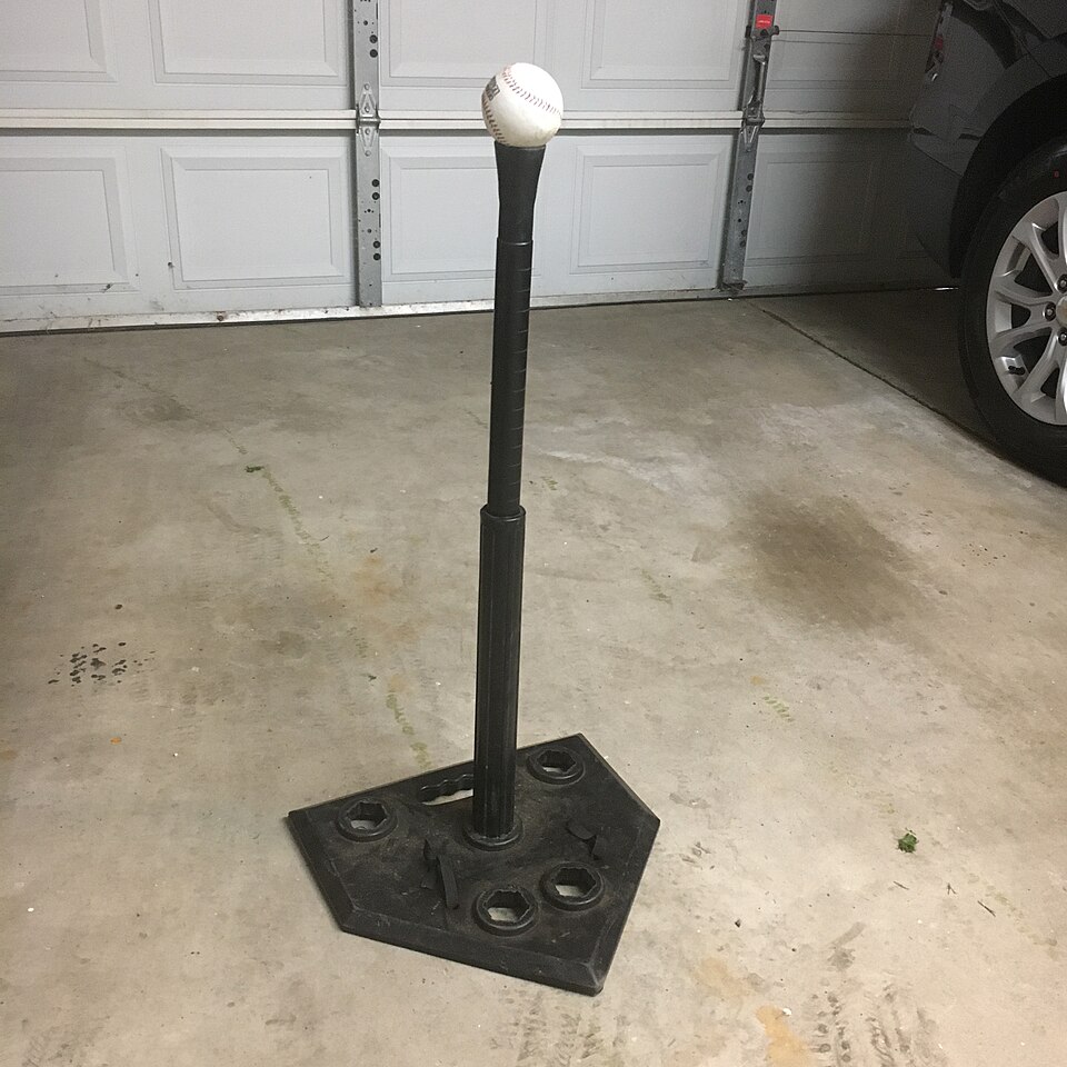 Baseball on a batting tee in a garage, the simple home setup a good baseball instructor in North Texas will assign homework around