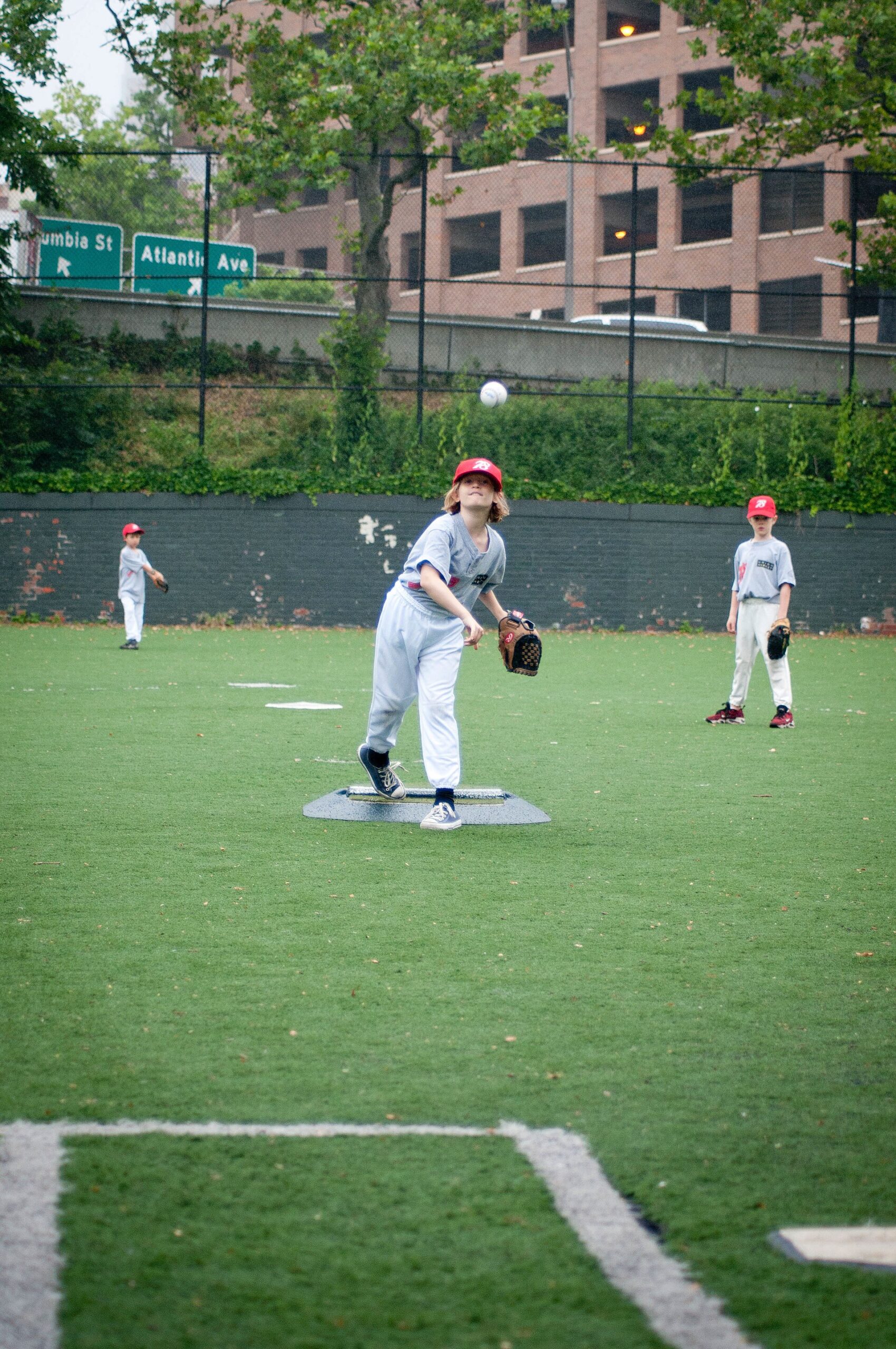 Little League pitcher delivering a pitch during a youth baseball game