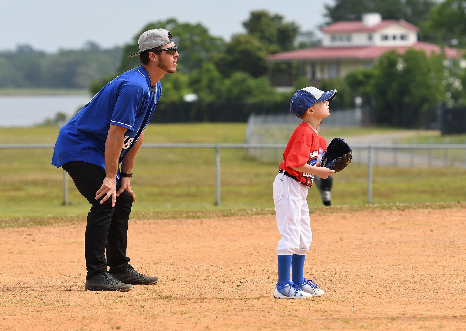 Young baseball player in ready position next to a coach, the moment baseball tryout anxiety hits kids hardest