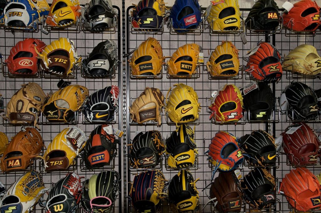 Store wall of baseball gloves from brands including Wilson, Rawlings, Mizuno and Zett