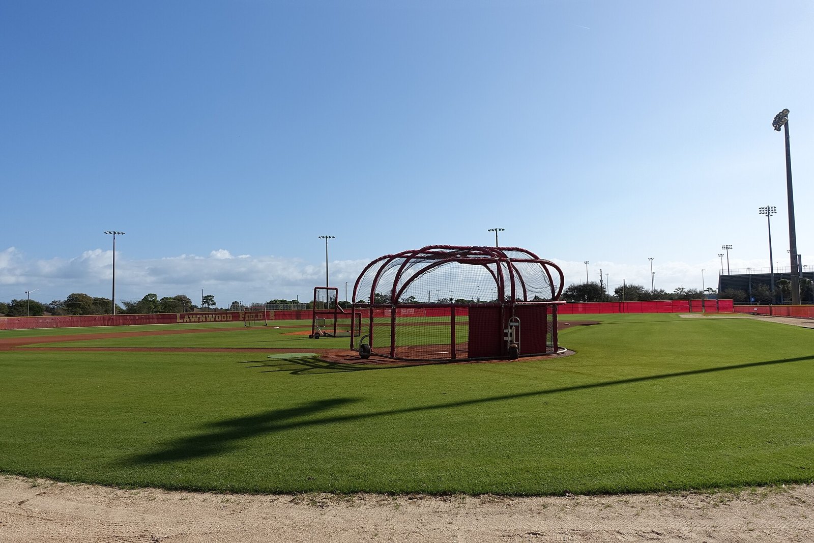 Multi-field youth baseball complex with dugouts and empty stands — travel load and complex quality matter when you evaluate a select baseball team