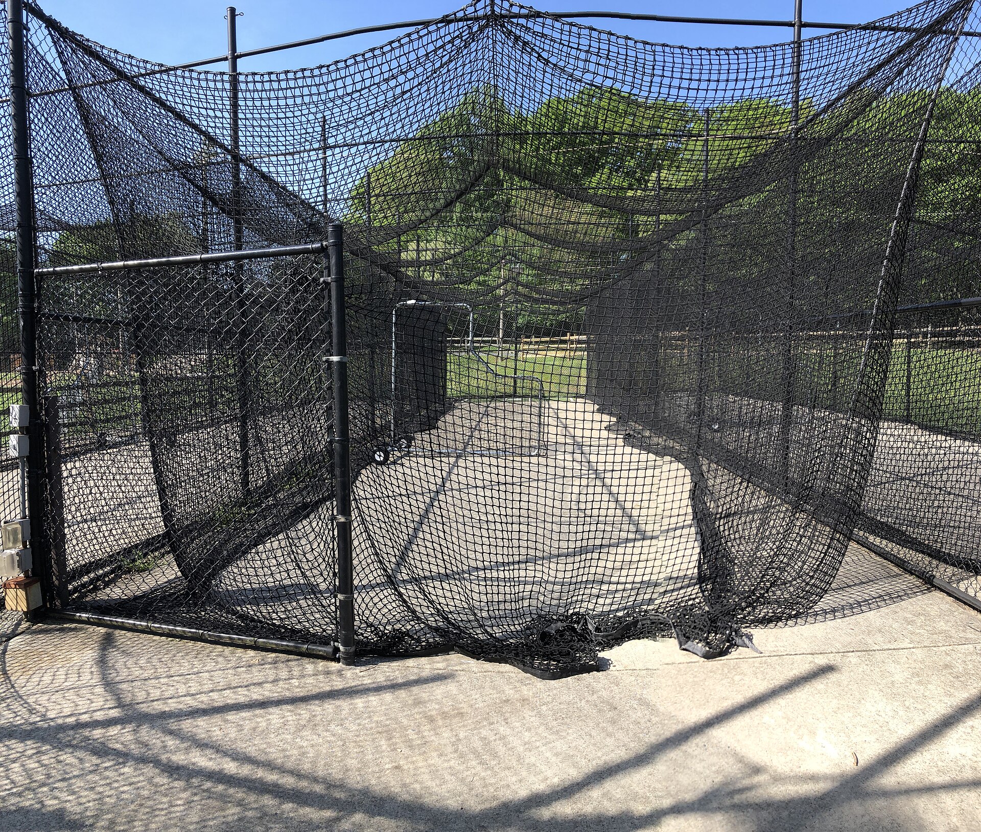 Long netted batting cage tunnel with an L-screen, the kind of rental tunnel offered at indoor baseball training facilities