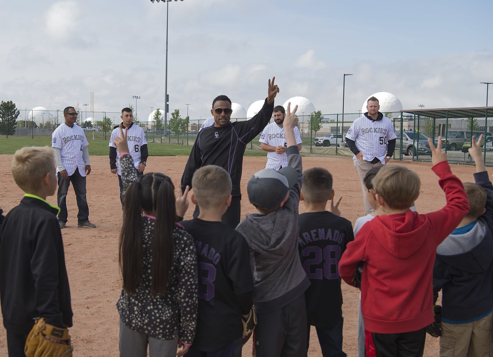 Coach sorting youth baseball players into numbered groups during a tryout-style clinic for North Texas select baseball tryouts