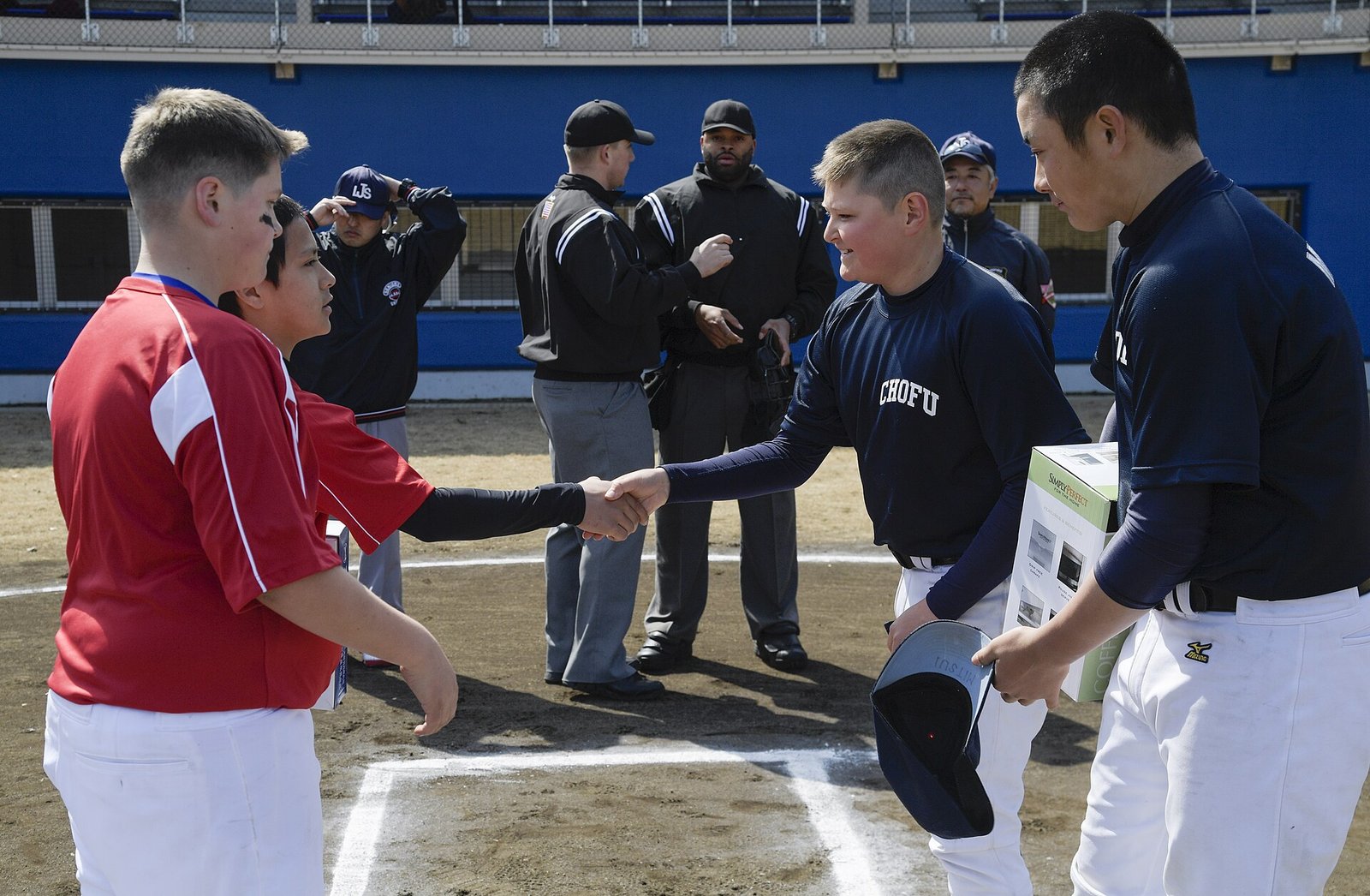 Youth baseball players and coaches shaking hands at home plate, leaving gracefully when you switch select baseball teams
